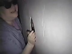 Зрелая толстуха в любительском видео сосёт чёрный член торчащий из дырки в стене