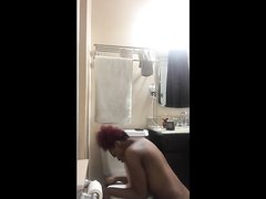 Рыжая негритянка перед домашней вебкамерой мастурбирует щель в туалете